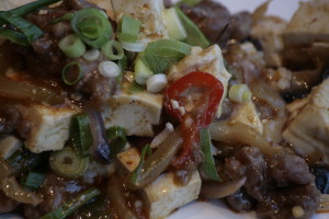 G6 Ma Pho Doufu Tofu en rundergehakt in een sojapastasaus met Szechuanpepers en ingelegde rettich.